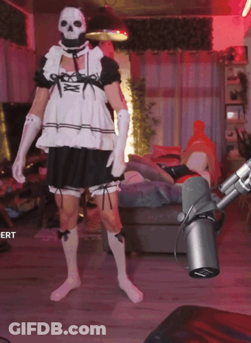 A Man In A Maid Costume Is Standing In Front Of A Microphone With The Word Ert On The Bottom GIF