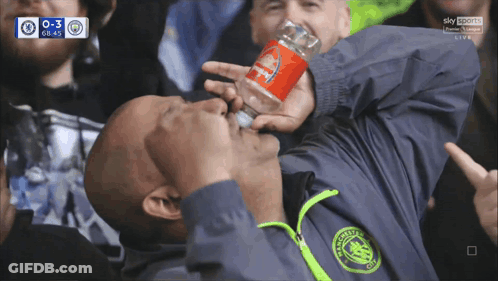 A Man In A Manchester City Jacket Drinks From A Coca Cola Can GIF