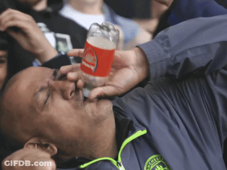 A Man In A Manchester Jacket Drinks From A Glass GIF