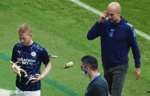 A Man In A Marathon Bet Shirt Holds A Trophy On A Soccer Field GIF