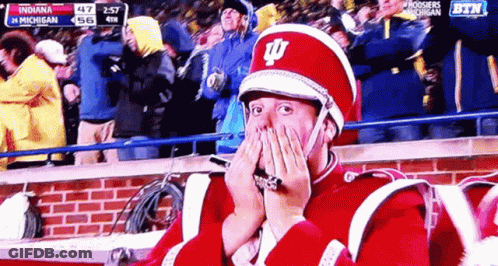 A Man In A Marching Band Uniform Covering His Face With His Hands GIF