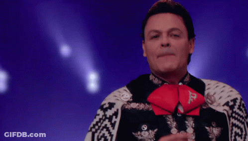 A Man In A Mariachi Outfit Has A Red Bow Tie With The Letter D On It GIF