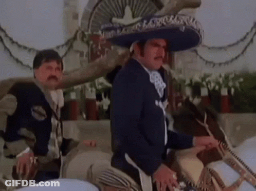 A Man In A Mariachi Outfit Is Riding A Horse . GIF