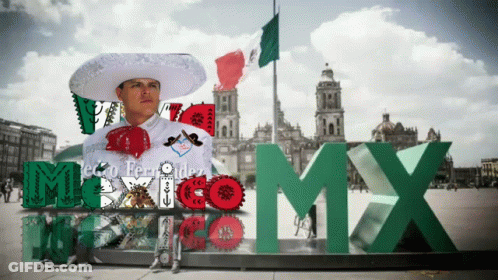 A Man In A Mariachi Outfit Stands In Front Of A Sign That Says Mexico GIF