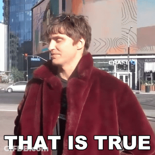 A Man In A Maroon Coat Says That Is True In Front Of A Chase Bank GIF