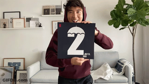 A Man In A Maroon Hoodie Is Holding A Sign With The Number 2 And The Date July 31 2020 GIF