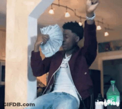 A Man In A Maroon Jacket Is Holding A Fan Of Money In His Hands . GIF