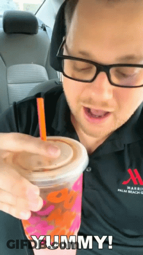 A Man In A Marriott Palm Beach Shirt Is Drinking A Dunkin ' Donuts Drink GIF