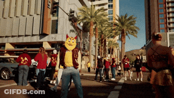 A Man In A Mascot Costume Stands On A Street GIF