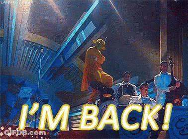 A Man In A Mask Is Dancing On A Stage With A Band And The Words I 'M Back GIF