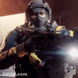 A Man In A Mask Is Holding A Gun In His Hand . GIF