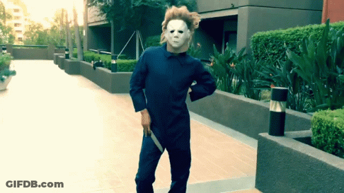 A Man In A Mask Is Holding A Knife In His Hand GIF
