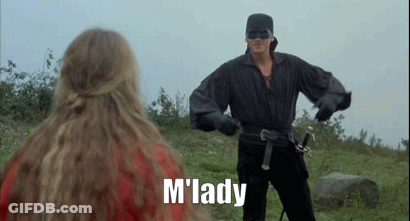 A Man In A Mask Is Holding A Sword In Front Of A Woman In A Red Dress . GIF