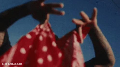 A Man In A Mask Is Holding A Woman In A Red And White Dress . GIF