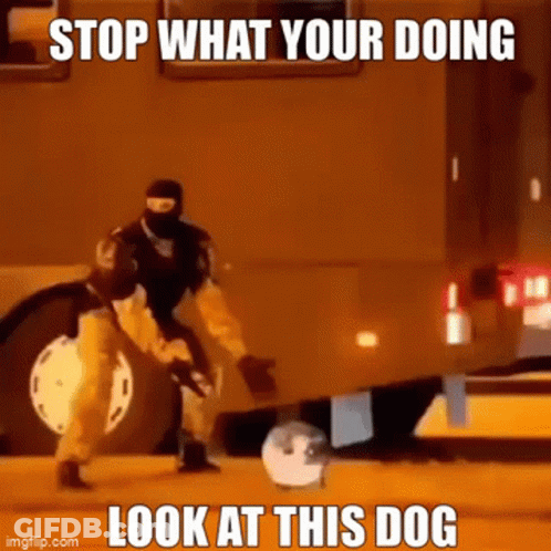 A Man In A Mask Is Kicking A Ball In Front Of A Truck . GIF