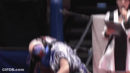 A Man In A Mask Is Laying On The Ground In A Wrestling Ring GIF