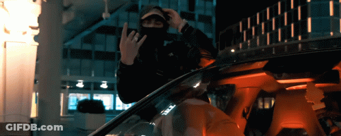A Man In A Mask Is Sitting In A Car And Giving The Middle Finger GIF