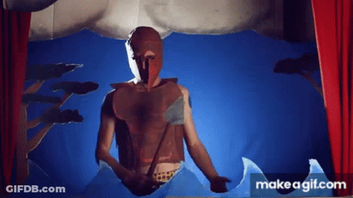 A Man In A Mask Is Standing In Front Of A Red Curtain . GIF