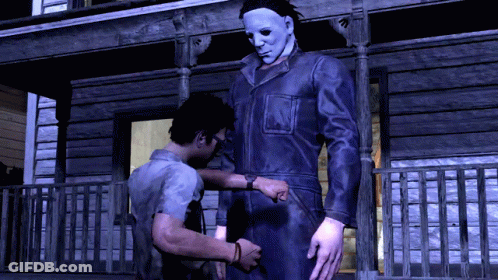 A Man In A Mask Is Standing Next To A Man In A Jumpsuit GIF