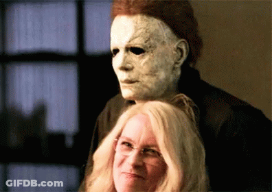 A Man In A Mask Is Standing Next To A Woman . GIF