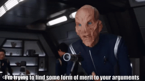 A Man In A Mask Says I 'M Trying To Find Some Form Of Merit To Your Arguments While Holding A Gun GIF