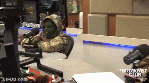 A Man In A Mask Sits In Front Of A Microphone With The Breakfast Club Written On The Bottom GIF
