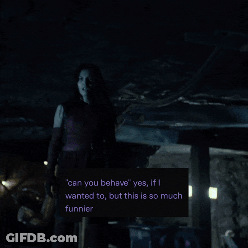 A Man In A Mask Stands In A Dark Room With A Green Light Behind Him GIF