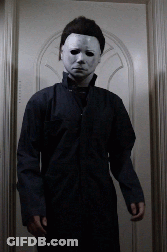 A Man In A Mask Stands In Front Of A Door That Says ' Elevator ' GIF