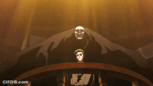 A Man In A Mask Stands In Front Of A Large Monster GIF