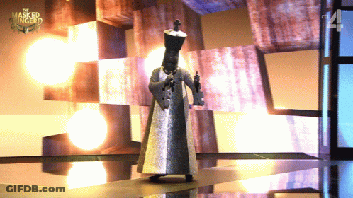 A Man In A Masked Singer Costume Is Standing On A Stage GIF