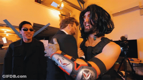 A Man In A Matrix Costume Is Being Hugged By Another Man GIF