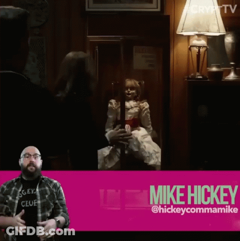 A Man In A Mickey Club Shirt Stands In Front Of A Pink Sign That Says Mike Hickey GIF