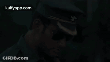 A Man In A Military Uniform And Sunglasses Is Wearing A Hat . GIF