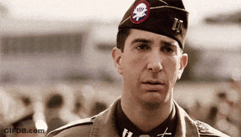 A Man In A Military Uniform Has A Patch On His Hat That Says Ii . GIF