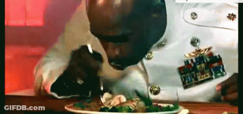 A Man In A Military Uniform Is Eating A Salad With A Fork . GIF