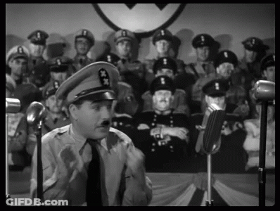 A Man In A Military Uniform Is Giving A Speech In Front Of A Crowd Of Soldiers . GIF