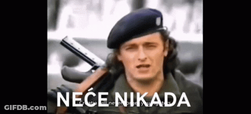 A Man In A Military Uniform Is Holding A Gun . GIF