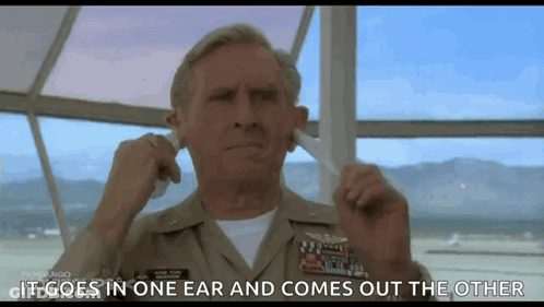 A Man In A Military Uniform Is Plugging His Ears In A Movie Scene . GIF
