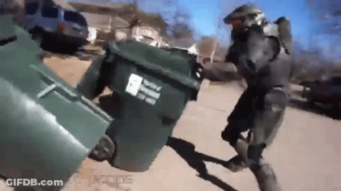 A Man In A Military Uniform Is Pushing A Trash Can Down A Street . GIF