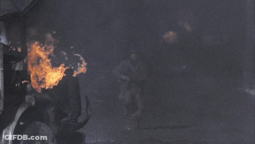 A Man In A Military Uniform Is Running In Front Of A Truck GIF