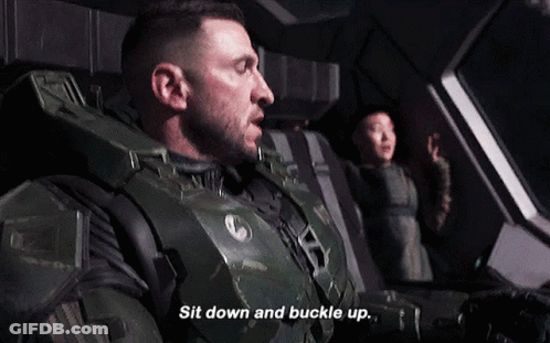 A Man In A Military Uniform Is Sitting Down And Buckle Up GIF