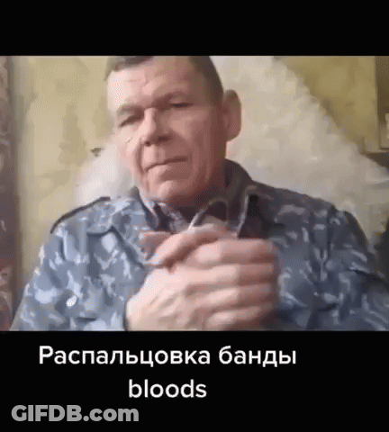 A Man In A Military Uniform Is Sitting In A Chair With His Hands Folded In Front Of Him . GIF