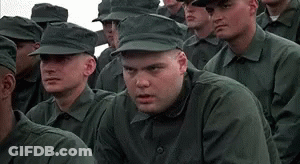 A Man In A Military Uniform Is Sitting In A Row Of Soldiers . GIF