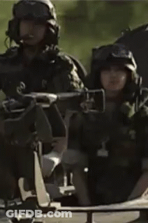 A Man In A Military Uniform Is Sitting In A Vehicle With Other Soldiers . GIF