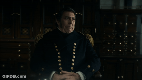 A Man In A Military Uniform Is Sitting In Front Of A Sign That Says That Is An Interesting Speculation GIF