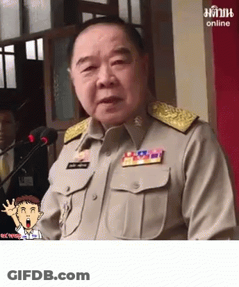 A Man In A Military Uniform Is Speaking Into A Microphone With A Cartoon Character Behind Him That Says Online On The Bo GIF