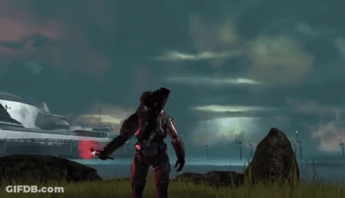A Man In A Military Uniform Is Standing In A Field With A Red Object In His Hand . GIF