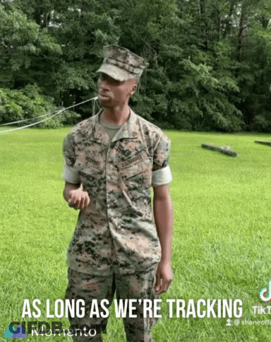 A Man In A Military Uniform Is Standing In A Grassy Field With The Words " As Long As We 'Re Tracking " Below Him GIF