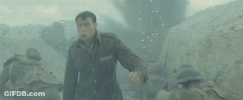 A Man In A Military Uniform Is Standing In A Trench . GIF