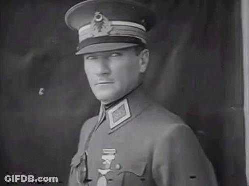 Man In Military Uniform In Front Of Black Wall GIF